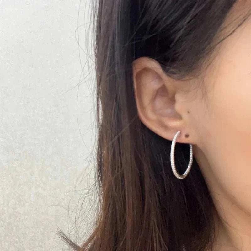 Woman wearing Moissanite Loop Earrings in 925 Sterling Silver.