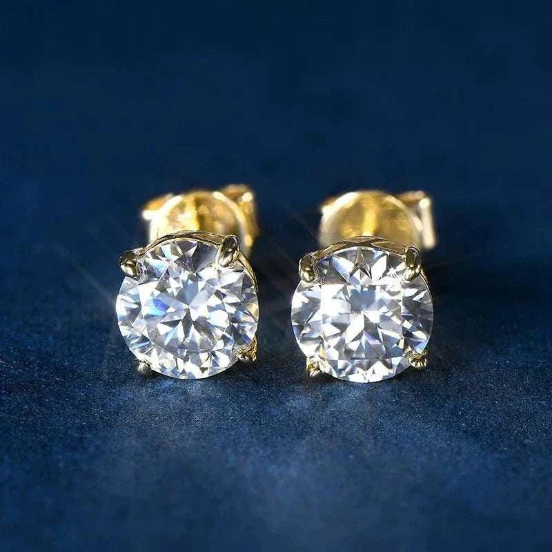 14k gold moissanite stud earrings with brilliant sparkle on dark blue background.
