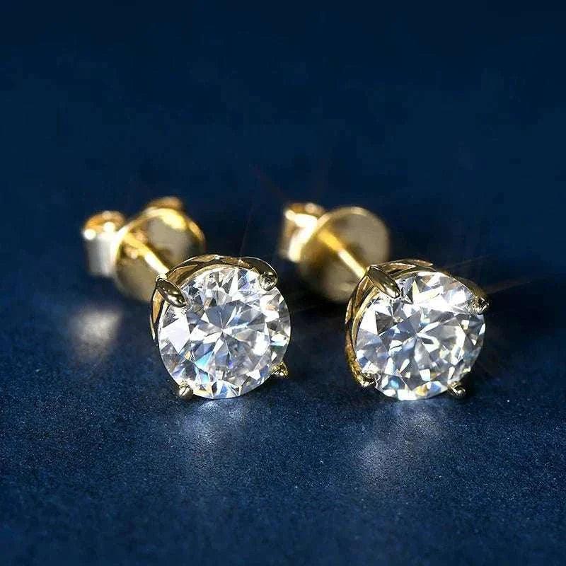 14k gold moissanite stud earrings with round stones on a dark background.