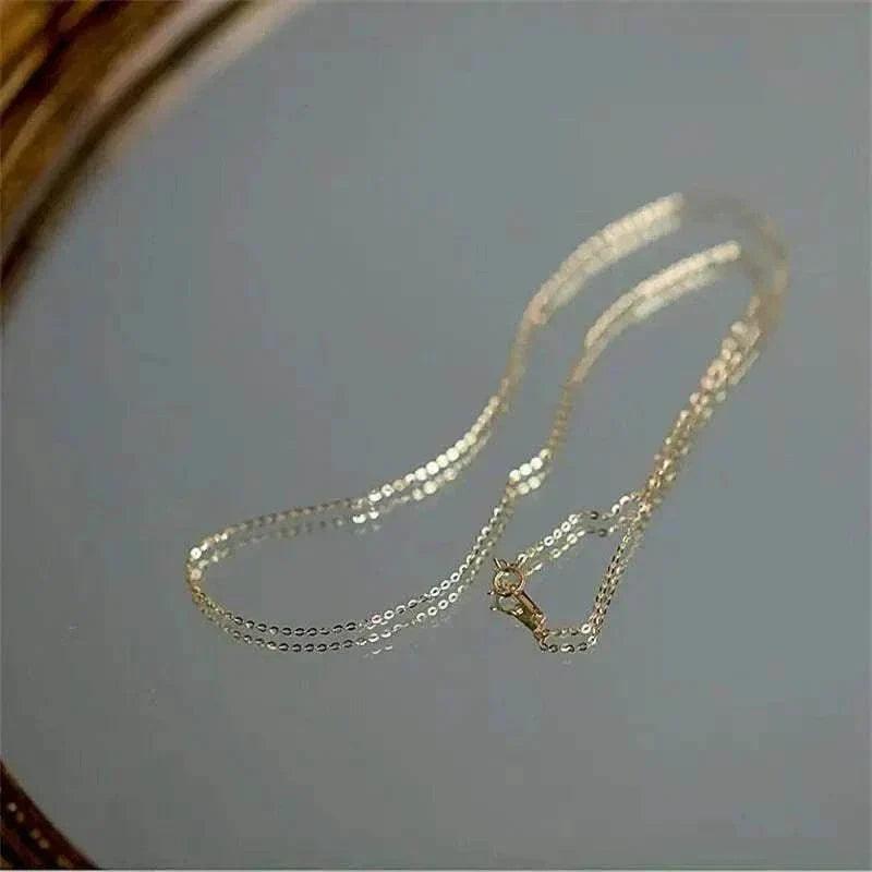 14K solid gold timeless minimalist necklace on reflective surface.