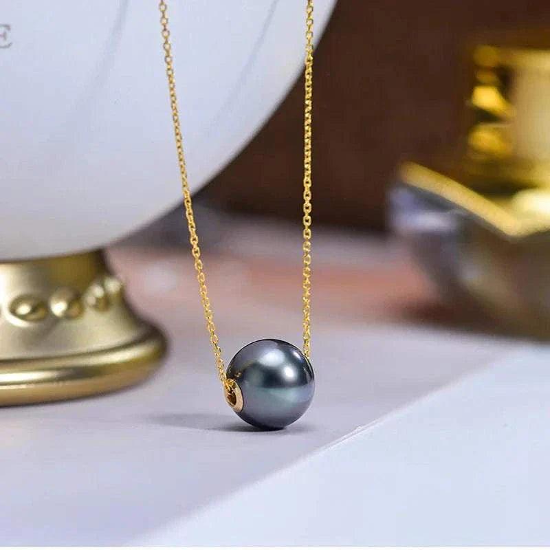 18k gold Tahitian black pearl pendant necklace with glossy pearl and gold chain.