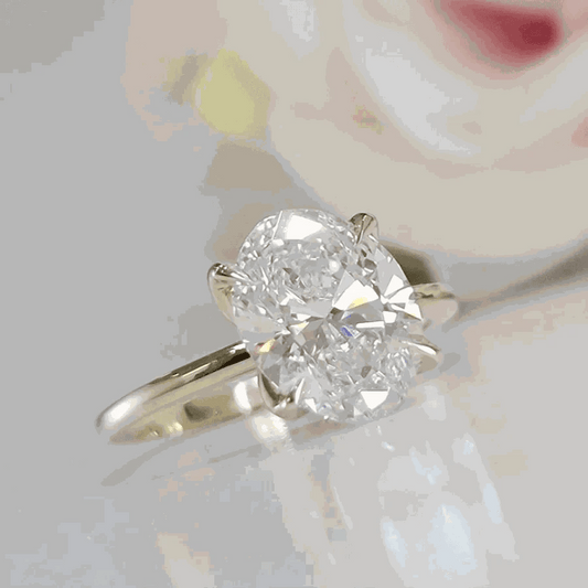 3 carat oval lab grown diamond engagement ring on 14K yellow gold band.