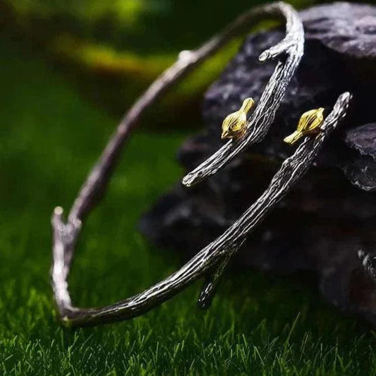 Adjustable 925 sterling silver bird bangle for women on green background, showcasing elegance and nature.