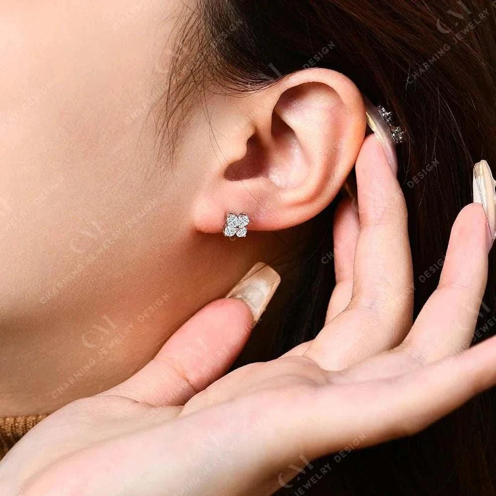 Dazzling moissanite flower earrings in gold or silver on ear, featuring round-cut diamond shimmer.