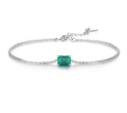 Elegant 925 silver bangle featuring a radiant emerald and moissanite gems.