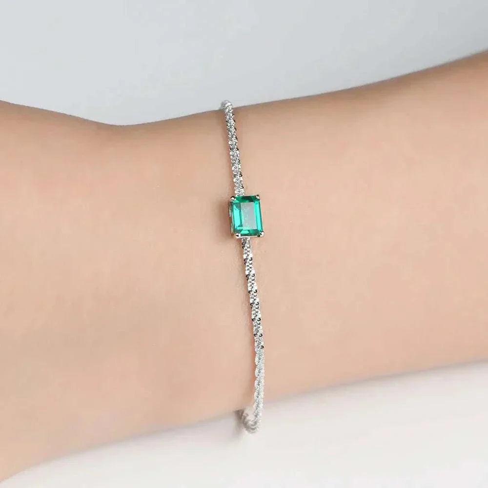 Elegant 925 silver emerald moissanite bangle on wrist.