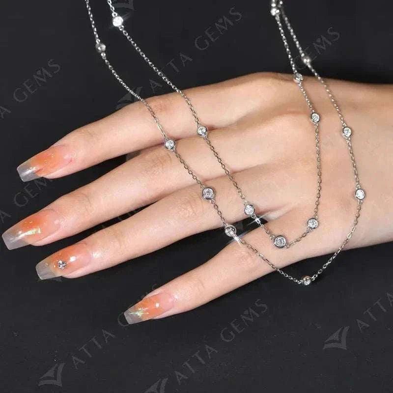 Elegant 925 silver moissanite necklace draped gracefully over a hand with long nails.