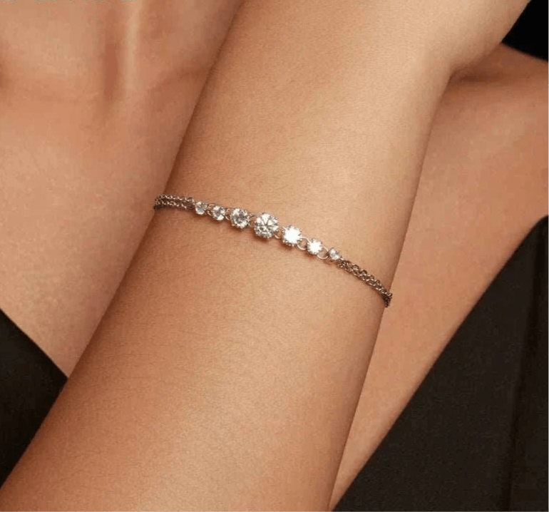Elegant adjustable moissanite bracelet on woman's wrist, showcasing sparkling stones in gradient design.