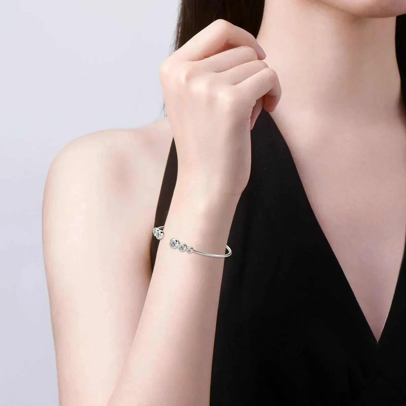 Elegant moissanite bracelet in 925 silver on woman's wrist showcasing exquisite sparkle.