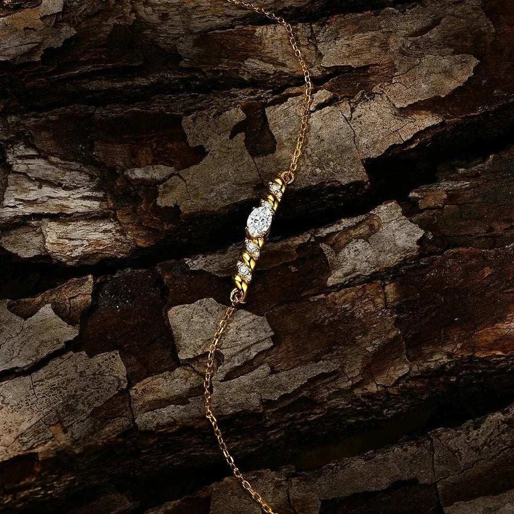 Elegant Moissanite Oval Cut Bracelet with Yellow Gold Plating on Wood Background.