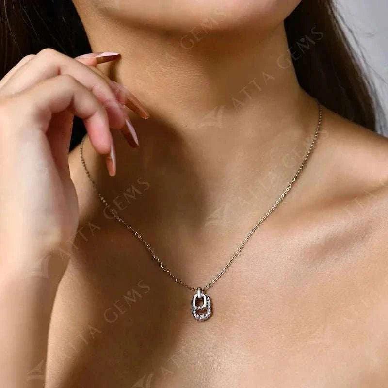 Luxury moissanite pendant necklace in silver on woman’s neckline.
