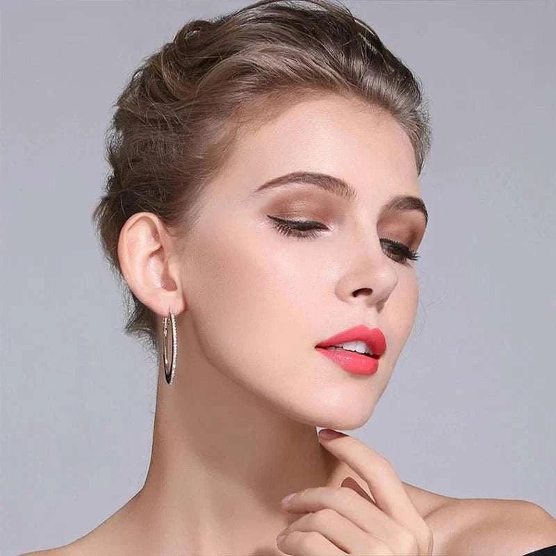 Elegant woman wearing moissanite loop earrings crafted from 925 sterling silver.