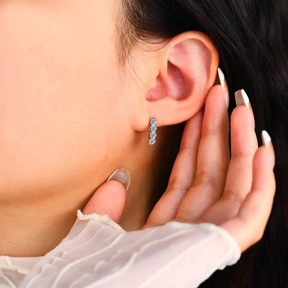 Moissanite stud earrings on ear, elegant diamond alternative.
