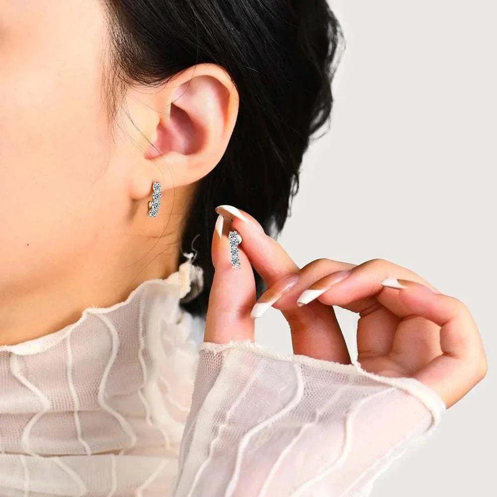 Moissanite stud earrings on woman, elegant diamond alternative.