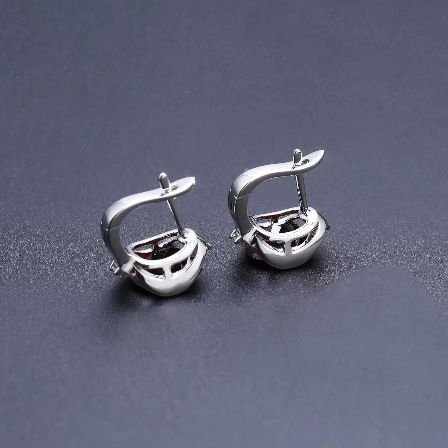 S925 silver natural garnet stud earrings with vibrant red gemstones on dark background.