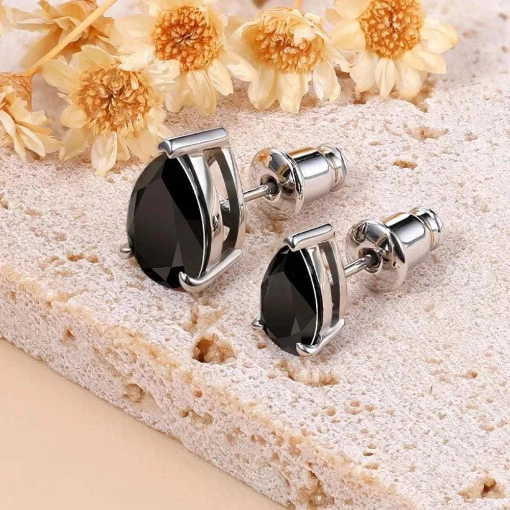 Timeless moissanite sterling silver stud earrings with pear-cut stones and floral background.